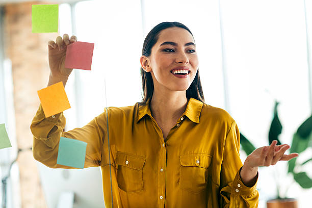 istock Qualified professional young woman engaging in a teamwork session using colorful notes in a luminous and modern office environment 2210518421