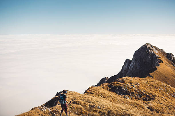 istock Hiker on Mountain Peak Above Sea of Clouds 2210518594