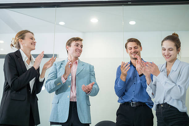istock Team celebrates project success with applause in a modern office setting during a bright afternoon meeting 2210519834