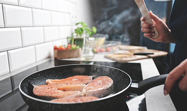 istock Red Fish Salmon Frying In A Pan On The Kitchen Stove 2210521844