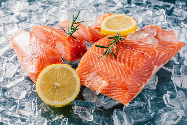istock Fresh Salmon Fillets with Lemon and Rosemary on Ice for Culinary Presentation 2210522486