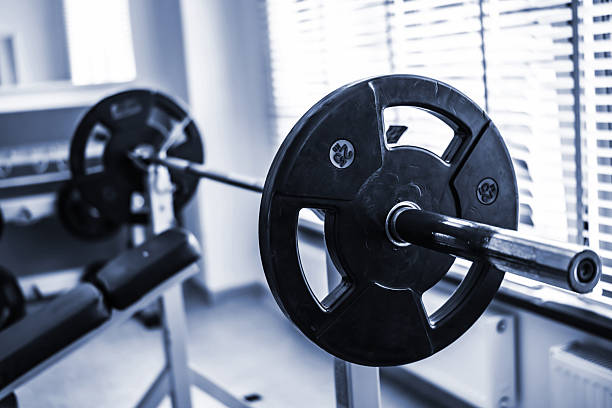 Barbell With Weights On Rack In Gym With Bench For Chest Press