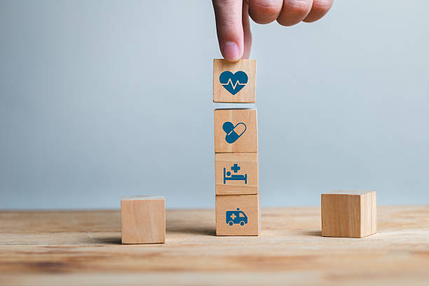 istock Hand Stacking Wooden Blocks with Health Icons on a Table 2210523685