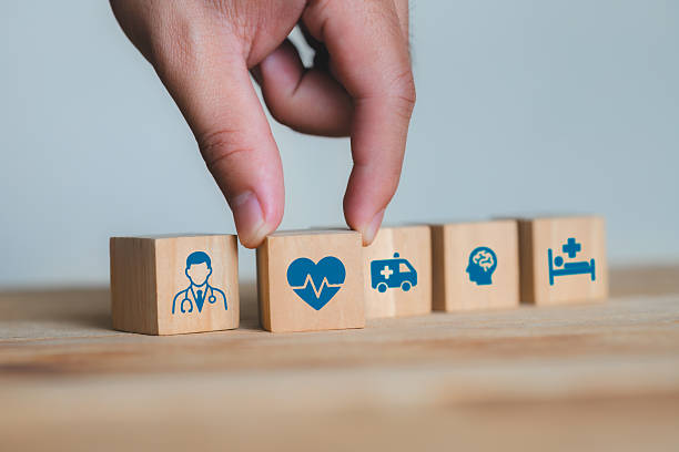 istock Hand Picking Health Icons from Wooden Blocks on a Table Surface 2210523691