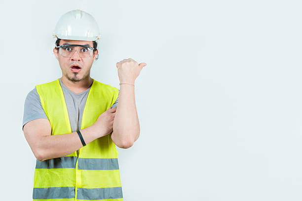 istock Surprised latin engineer pointing side advertising space isolated. Amazed male engineer pointing at a promotion on isolated background 2210527273