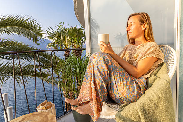 istock Woman Relaxing on Balcony with Morning Coffee 2210529664