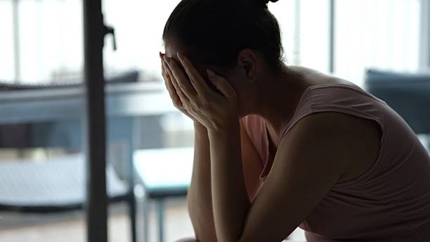 istock Sad woman crying covering face with hands at hotel 2210530044