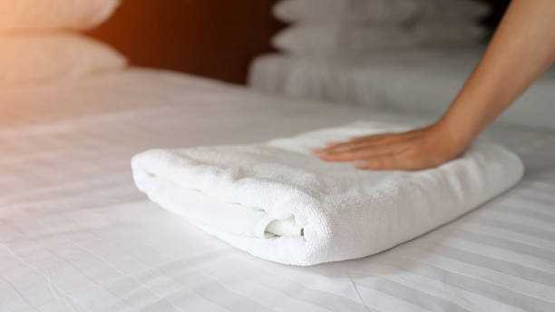 istock Hotel maid folding white towels on bed 2210530046