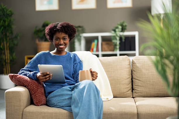 istock Relaxing on the couch, a Black woman enjoys some screen time on her tablet 2210531076