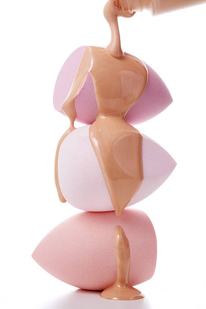 istock Three pastel-colored makeup sponges are stacked vertically, with liquid foundation dripping over the top sponge. 2210532888