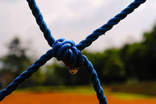Macrophotography Blue plastic rope knot. Closeup shot of knot rope of goal net. Knots and braids. Sports and entertainment. Textured Wallpapers. Copy space. Bokeh shots. Graphic Design