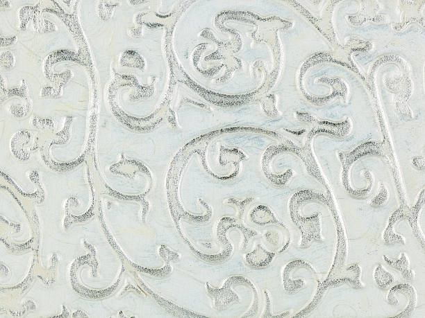 istock White textured faux leather surface revealing intricate silver floral embossing, presenting refined decorative texture with metallic sheen 2210534933