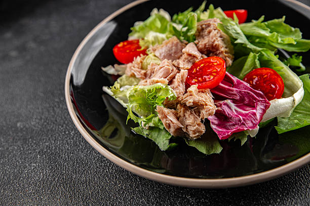 istock Tuna salad canned fish mixed green leaf lettuce seafood appetizer vegetable dish organic fresh tasty gourmet food background on the table rustic top view copy space vegetarian food pescetarian diet 2210537487