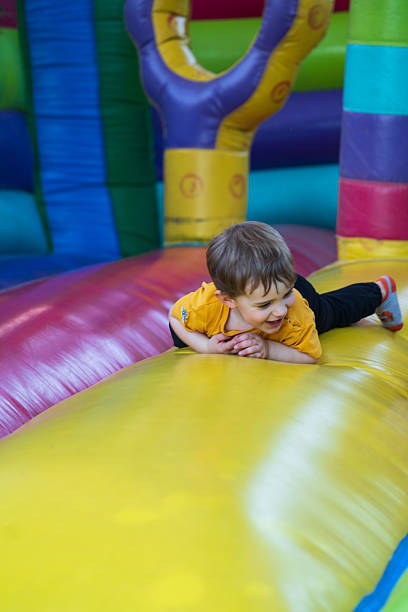 istock Child crawling and playing on inflatable bouncy castle 2210537665