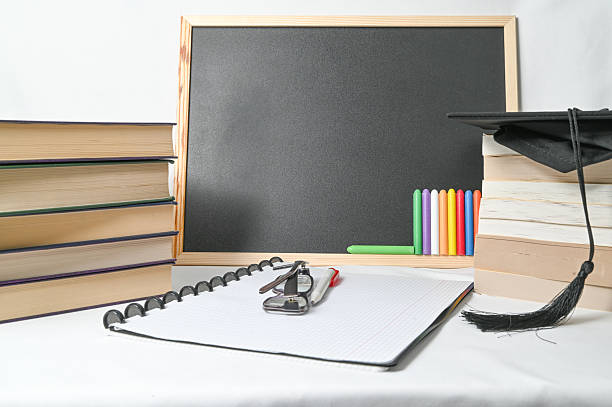 istock A graduation cap is placed beside a chalkboard along with a notebook 2210541497