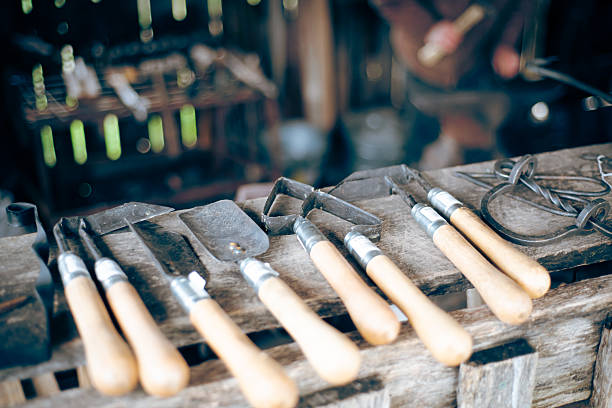 istock Traditional trade workshop with garden hand tools display, blurry blacksmith man working, trowel, transplanter, cultivator, weeder with carbon steel head, wooden handle grip, Mansfield, Missouri 2210543588