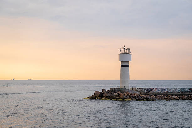istock Bosphorus lighthouse illuminated by sunset with ships in the distance creating a serene atmosphere on the water 2210544295
