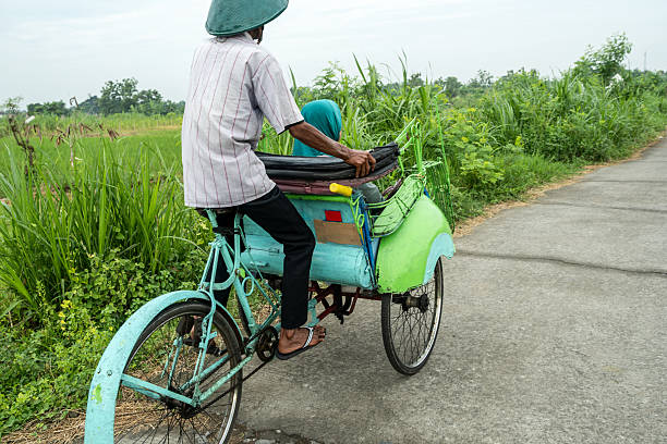 istock Indonesian cycle rickshaw driver transporting passenger on rural road 2210544533