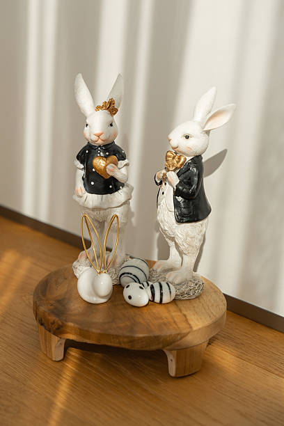 istock Ceramic Bunny Figurines with Gold Hearts on Wooden Stand 2210545946