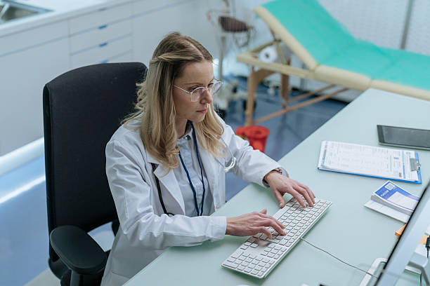 istock Female doctor writing on a keyboard, making last notes before finishing work 2210546578