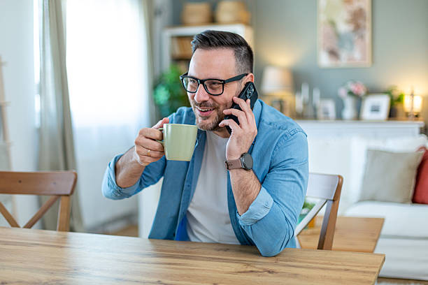 istock Smiling man talking on the phone and drinking coffee 2210554455