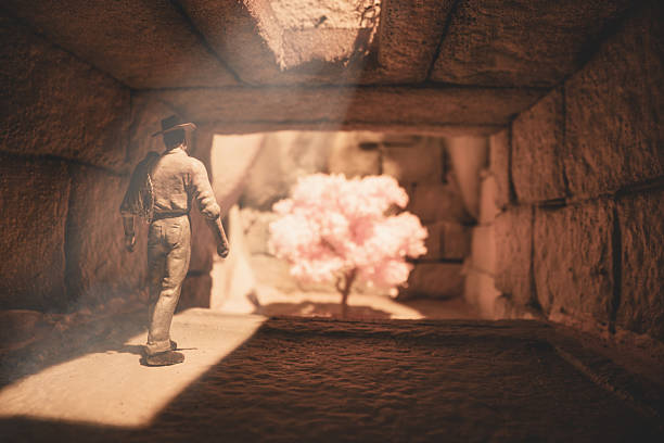 An adventurous explorer makes his way down a stone corridor to find a stone chamber and a brightly coloured tree, possibly the fabled Tree of Life. Scale model photography.