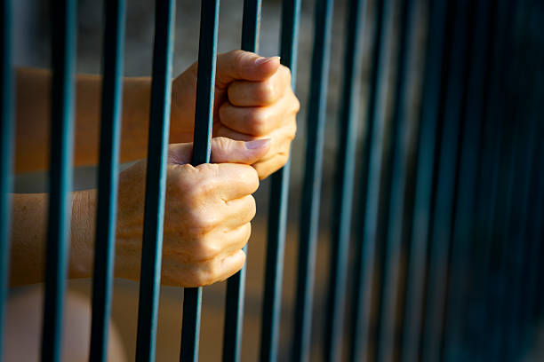 istock Hands Gripping Metal Bars Symbolizing Confinement and Despair 2210558486