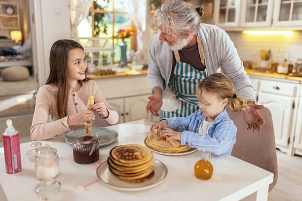istock Grandpa helps his grandchildren make pancakes 2210558721