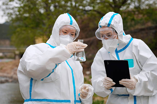 istock Laboratory Researchers Analyzing Data and Samples in Protective Gear Outdoors 2210562281