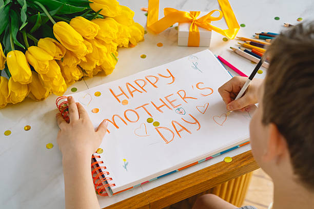 istock A boy diligently creating a heartfelt Mothers Day card 2210562787