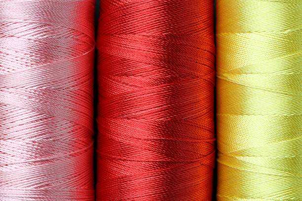 Spools of colorful sewing threads as background, top view