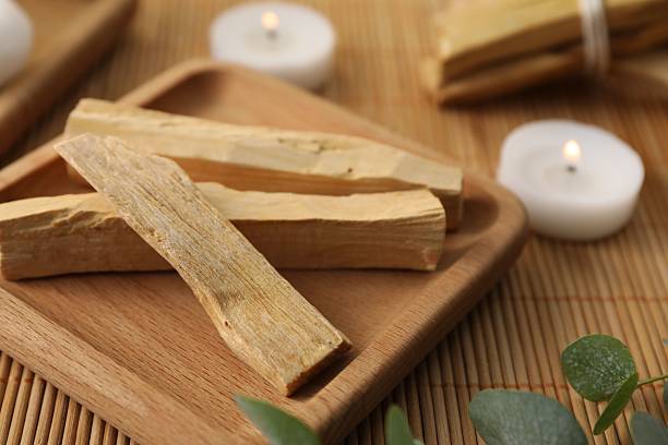 istock Palo santo sticks, eucalyptus branches and burning candles on bamboo mat, closeup 2210567979