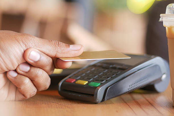 istock contactless payment concept with young man paying with credit card 2210568969