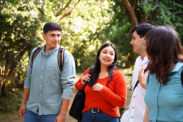 istock Group of students walking and talking together in a park 2210571265