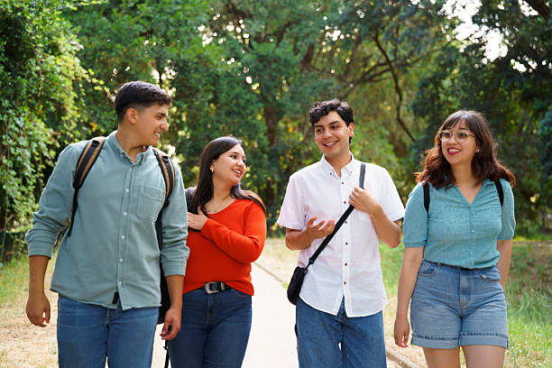 istock University students walking and talking in a park 2210571271