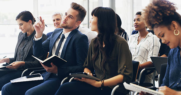 istock Question, group and business people at seminar with notes for corporate training, development or PR presentation. Audience, men and women at press conference for information, learning and growth 2210571447