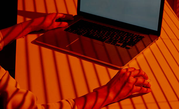 istock Woman Using Laptop and Mouse in Sunset Shadow Light. 2210572403