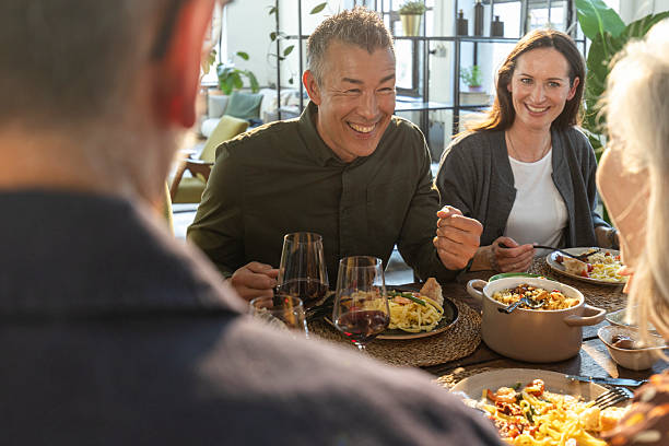 istock Smiling Diverse Friends Enjoying Dinner Party in Bright Modern Indoor Setting 2210572835