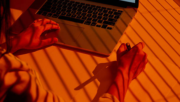 istock Woman Drawing on Paper with Laptop in Sunset Light. 2210572986