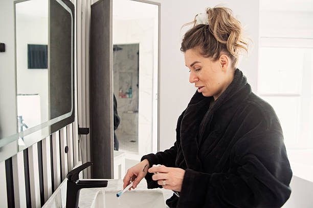 istock Woman brushing her teeth in bathroom. 2210573364
