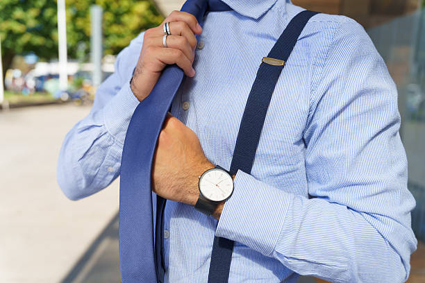 Businessman adjusting his tie and checking the time on his wristwatch, getting ready for a busy day