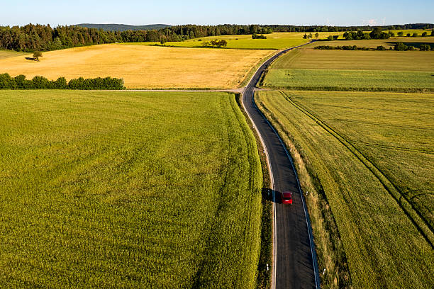 istock Red car driving on rural road 2210576335