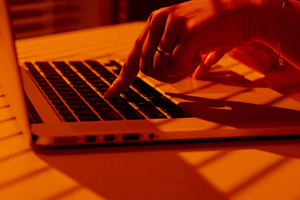 istock Female Hand Typing on Laptop in Sunset Light with Shadow Patterns. 2210576921