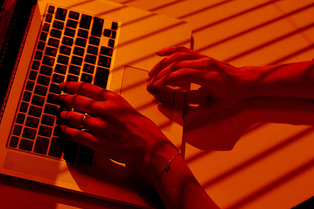 istock Woman Working on Laptop with Blinds Shadows in Warm Light. 2210577343