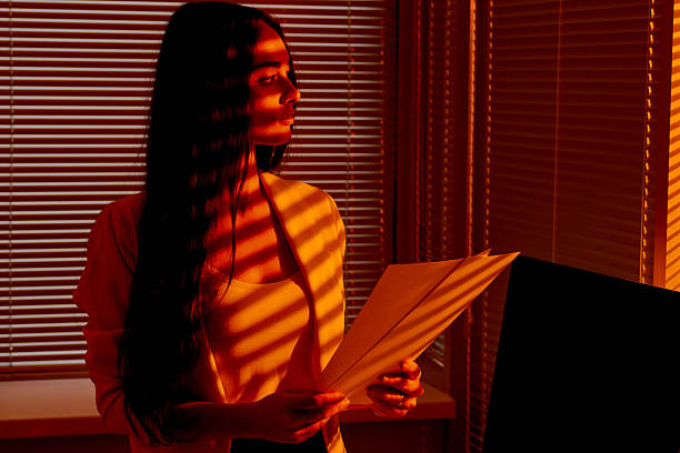 istock Business Woman Holding Documents in Golden Hour Office Light. 2210577437