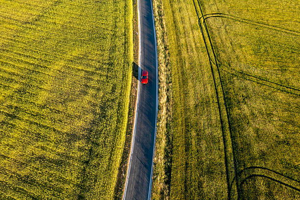 istock Red car driving on rural road 2210577851