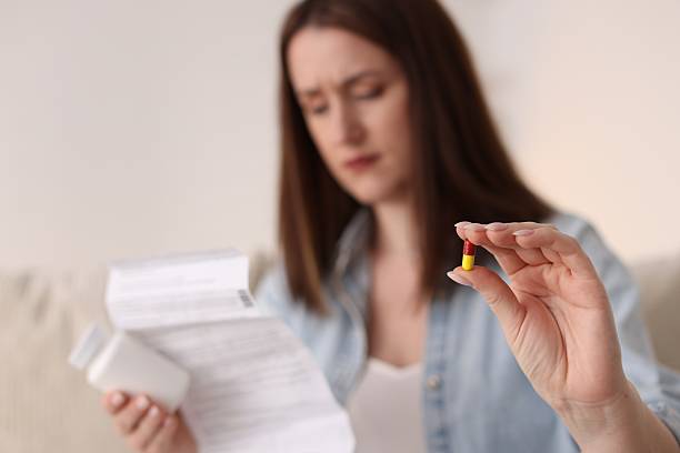 istock Woman with pill and instruction, selective focus 2210578396