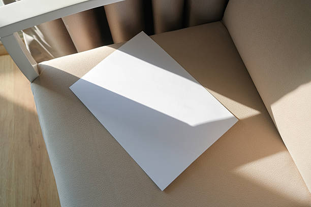 istock blank paper mockup on elegant soft armchair , shadow overlay, morning light 2210579525