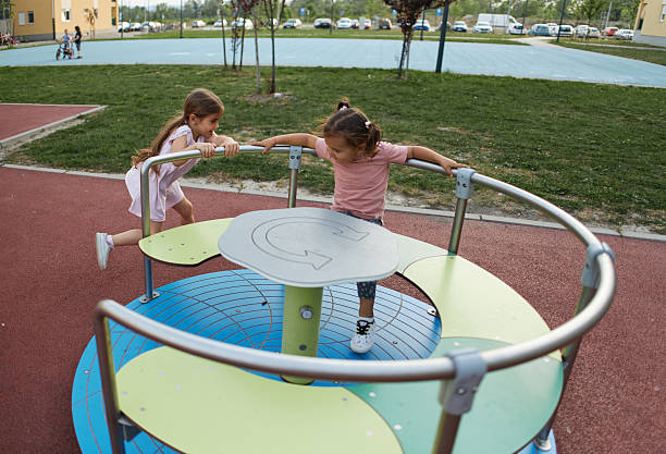 istock Spinning around! Girls enjoying playground! 2210580299