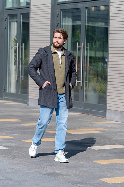 istock Man in stylish outfit walking in urban setting during daylight hours 2210584163